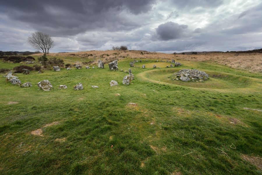 Beaghmore Stone Circles showing a grassy area with a stone circle and large pile of stones 