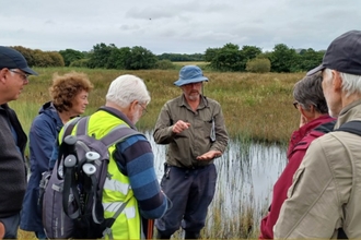 Dr Peter Jones sharing his peatland expertise to a group of people on an Eisteddfod-linked visit to Cors Geirch in collaboration with Cymdeithas Edward Llwyd (Welsh natural history group). Credit Natural Resources Wales.