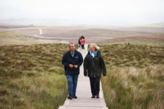 Minister Poots and Jennifer Fulton, CEO of Ulster Wildlife walking along a boardwalk on a peatland