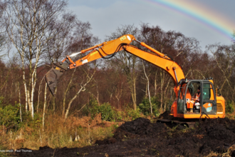 Machine operator undertaking peatland restoration at Risley Moss
