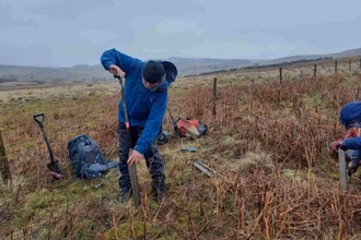 Person taking a peat core using a Russian corer.