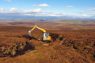 Machine operator reprofiling a gully Pennine PeatLIFE