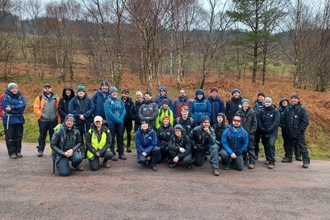 Around 30 peatland restoration practitioners standing next to a raised bog.