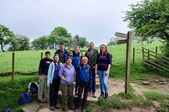 IUCN team of eight people standing by a fingerpost on Kinder Scout