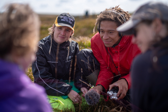 A group of people being interviewed on a peatland.