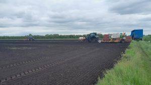 Farm machinery in a field of bare peat