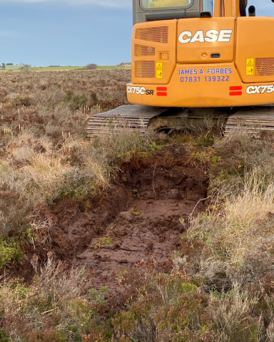 Digger digging a borrow pit for a peat dam