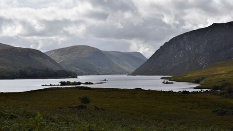Peatland landscape at Glenveagh National Park with a lough and mountains in the background