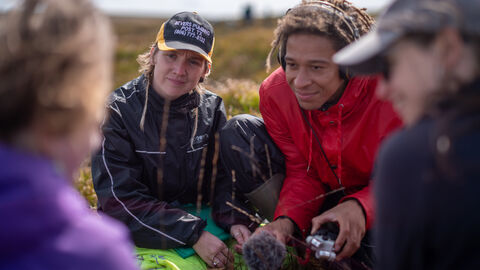 A group of people being interviewed on a peatland.