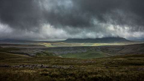 Moorland landscape with low, brooding clouds hiding a distant peak.