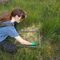 Jessica leaning over a 50x50cm gridded quadrat covering a hummock of sphagnum moss.