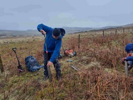 Person taking a peat core using a Russian corer.