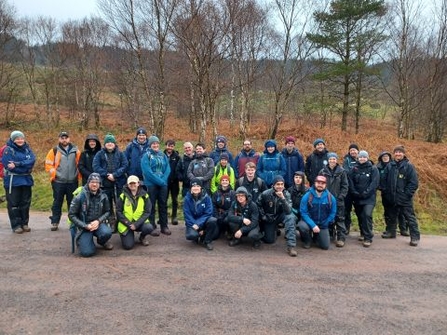 Around 30 peatland restoration practitioners standing next to a raised bog.