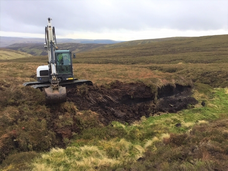 Digger carrying out restoration works on an area of peatland